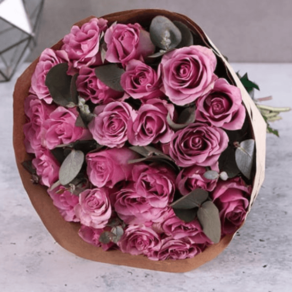 A stunning bouquet of 12 premium purple roses with eucalyptus leaves, perfect for gifting and flower delivery in Dubai.