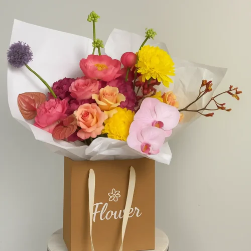 Sunset Mirage is a luxury mixed flower bouquet with orchids, roses, ranunculus, and chrysanthemums in a kraft bag, available for flower delivery in Dubai, UAE