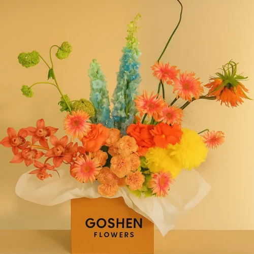 Desert Carnival is a vibrant mixed flower bouquet with yellow, coral, pink, and blue blooms in luxury box – available for same-day delivery in Dubai and UAE.