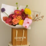 Sunset Mirage is a luxury mixed flower bouquet with orchids, roses, ranunculus, and chrysanthemums in a kraft bag, available for flower delivery in Dubai, UAE